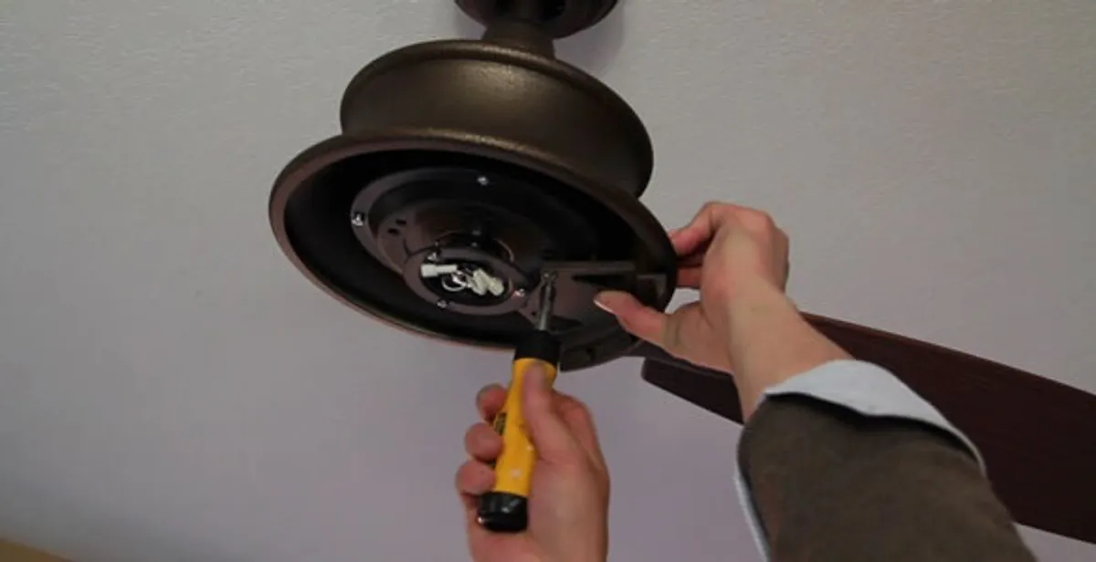 Electrician installing ceiling fan mounting bracket and fixture in Cincinnati, OH