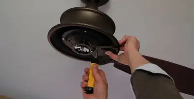 Electrician installing ceiling fan mounting bracket and fixture in Cincinnati, OH