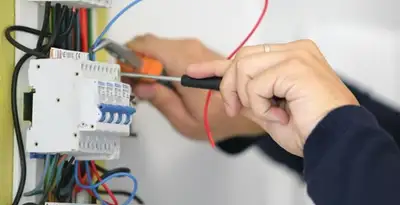 Electrician installing and adjusting circuit breakers in an electrical panel in Cincinnati, OH