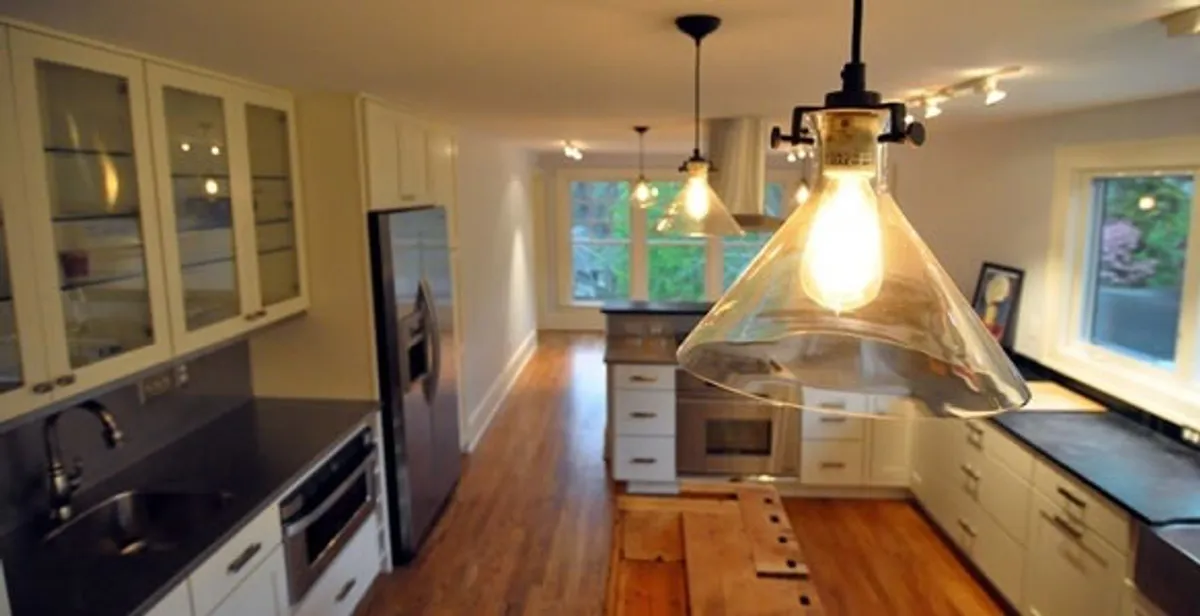 Residential electrician installing modern indoor light fixture in a home in Cincinnati, OH