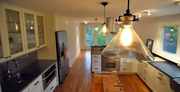Residential electrician installing modern indoor light fixture in a home in Cincinnati, OH