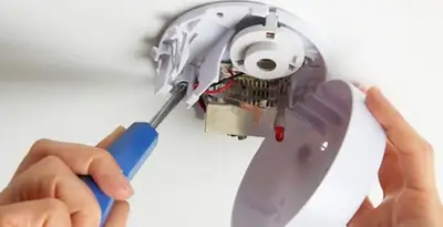 Certified technician wiring smoke detector during installation in Cincinnati, OH
